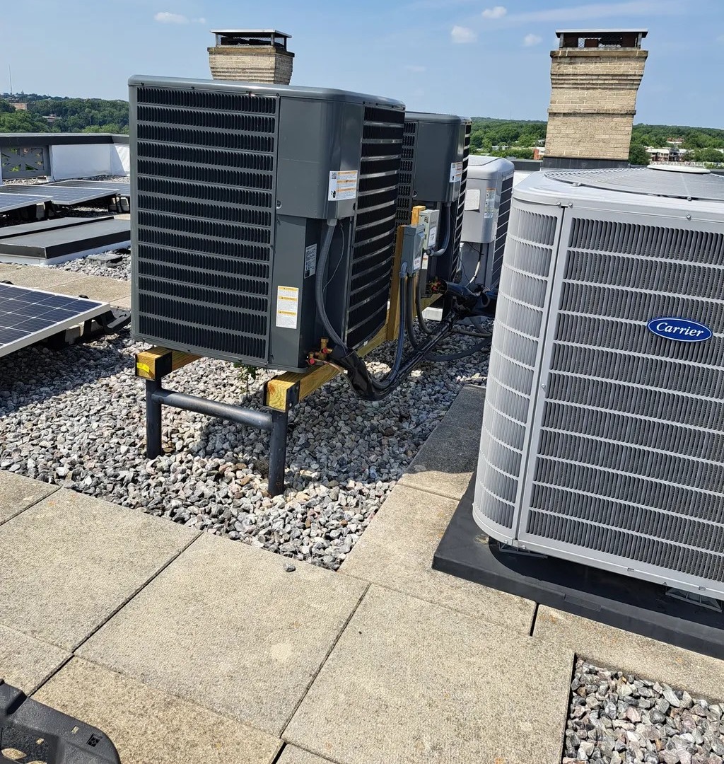 Condensers and a technician’s gauge set on a commercial rooftop