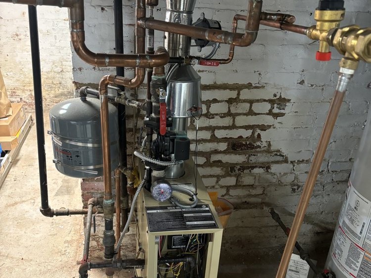 Boiler with copper piping and an expansion tank in a basement