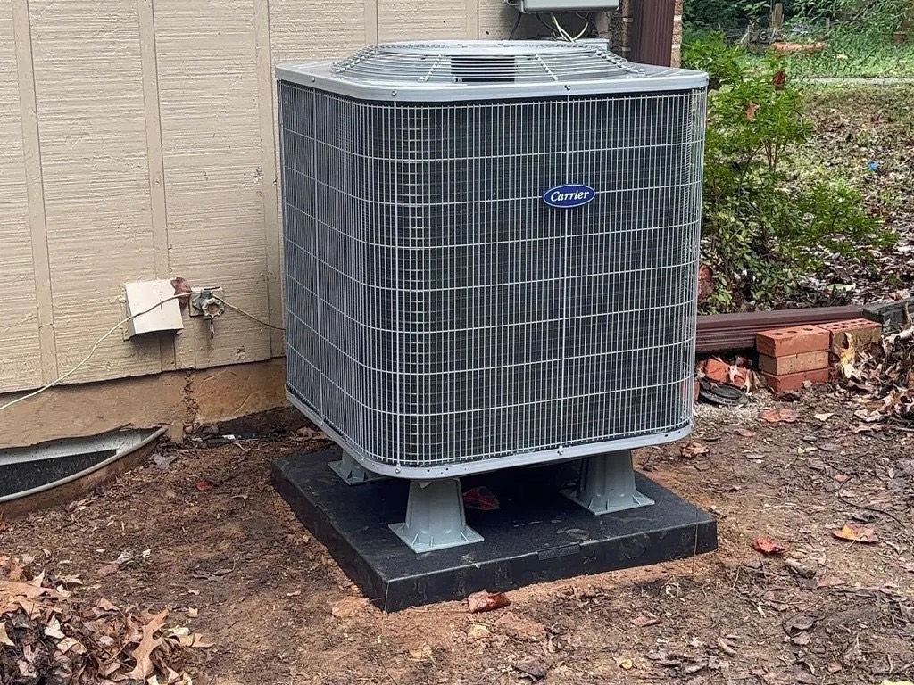 Condenser installed beside a brick wall with gauges connected